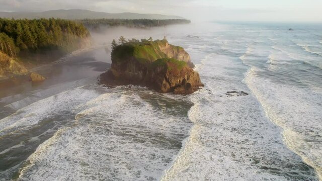 Flying over Ruby beach, Oregon, United States. Pacific waves and huge stones on the shore in sunset light. Aerial view of Pacific coast in USA