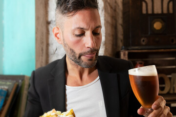 A young bearded man enjoying a beer in a pub. High quality photo