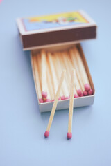 Matches in an open box on a pastel blue table