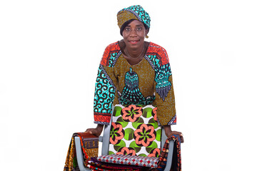 woman exposing several traditional loincloths on a chair smiling.