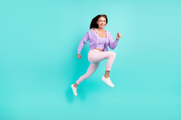 Fototapeta na wymiar Photo of energetic cheerful sporty lady jump run go wear violet cardigan isolated turquoise color background