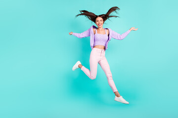 Photo of cute adorable young woman dressed purple clothes jumping high smiling isolated teal color background
