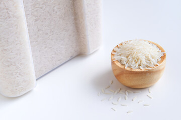 Obraz na płótnie Canvas Jasmine rice in measuring wooden bowl and grain pile, Container or Plastic box on white background, Keep dried storage and Agricultural organic produce, Staple food with carbohydrate of Asian people.