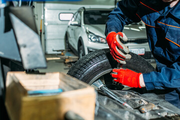 car service, tire fitting, an employee performs washing and wheel balancing on special installations