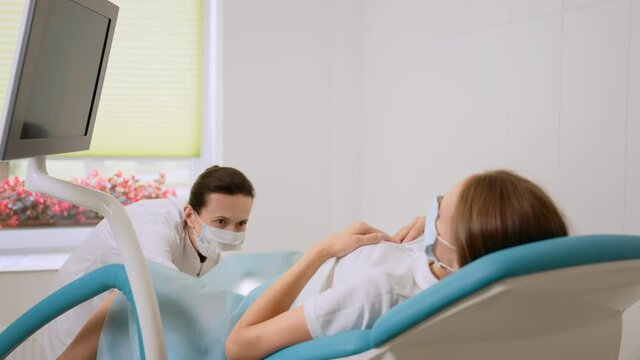 Female gynecologist in medical unifrom examining patient