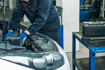 car service, an employee replaces and tests the car battery
