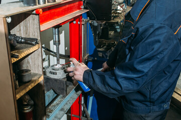 car service, an employee repairs and tests car parts