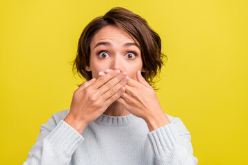 Photo of impressed young brunette lady close mouth wear blue sweater isolated on yellow color background