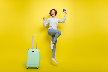 Photo of champion lady hold passport jump raise fists wear blue sweater jeans shoes isolated yellow color background