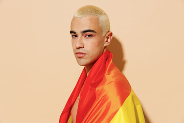 Side view sexy serious young blond latin gay man 20s with make up in beige tank shirt wrapped in...