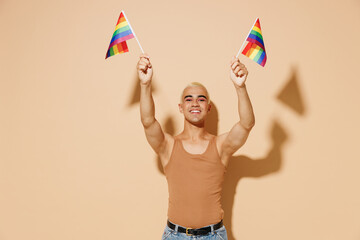 Young smiling happy activist blond latin gay man 20s with make up in beige tank shirt holding...