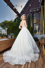Fototapeta premium Sexy beautiful blonde woman pretty bride wedding big day marriage ceremony in summer garden wearing long silk and lace white dress bright makeup hairstyle pure love interior.