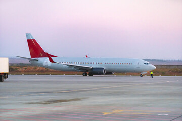 Passenger plane taking off from runway at airport on sunny day.