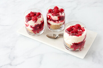 High Angle View of Three Glasses filled with Raspberry Dessert on Marble Board