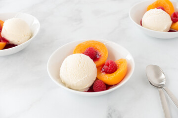 Vanilla Ice Cream with Peaches and Raspberries in Bowls