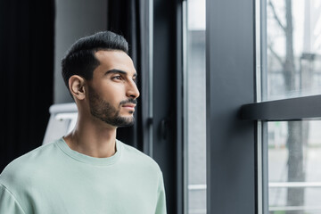 Young muslim businessman standing near window in office