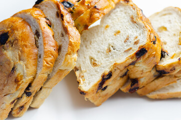 Fruit loaf with sultanas and orange flavored pieces on the white background