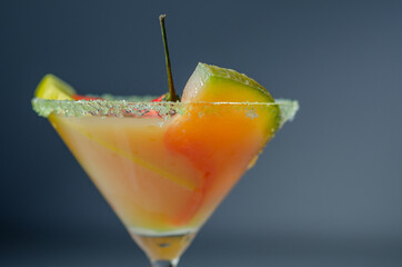 A holiday cocktail based on vodka, liqueur, fresh melon and red bird eye chilli, a refreshing drink prepared by a bartender
