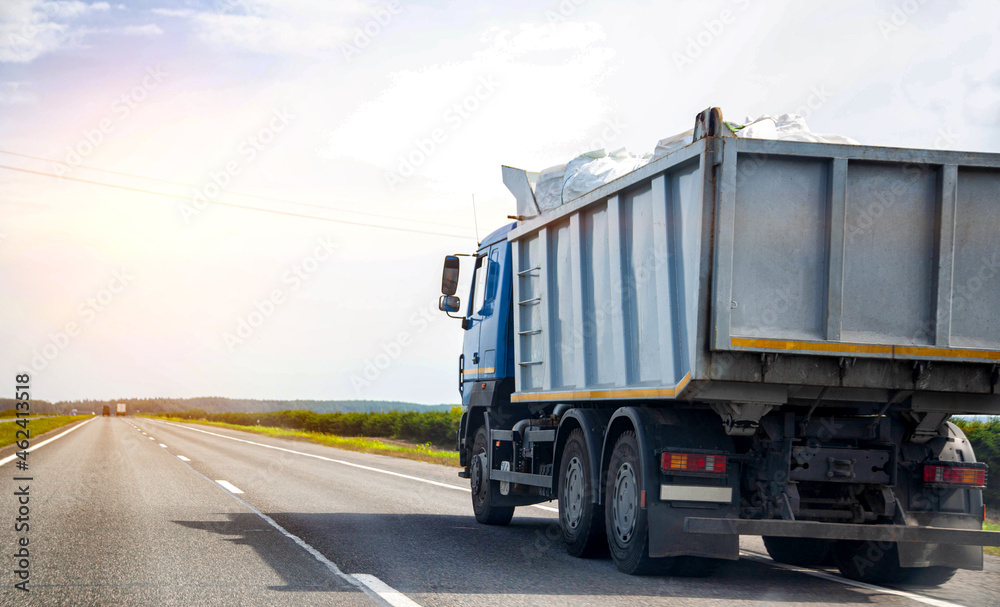 Wall mural transporting waste in a dump truck on the highway for recycling. transportation of recyclable materi