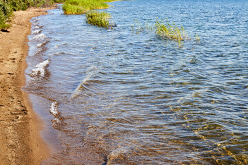waves breaking on the sandy shore of the lake