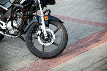 Front wheel with disc brake of a tourist motorcycle in the city. Copy space for text