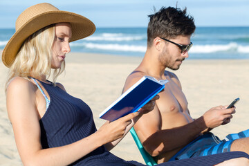 Fototapeta premium couple on holidays reading and using the phone