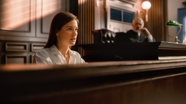 Court of Law and Justice Trial Stand: Portrait of Beautiful Female Victim Giving Heartfelt Testimony, Judge and Jury Listening. Dramatic Speech of Empowered Witness against Crime, Prejudice, Injustice