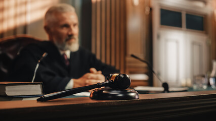 Cinematic Court of Law and Justice Trial: Honorable Male Judge Discussing Pleaded Case, Decision Guilty or Innocent Verdict after Hearing Arguments. Blurred Shot with Focus on Gavel