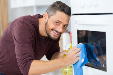 man cleaning oven in the kitchen