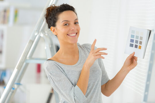 cheerful woman choosing colors to paint a room