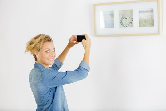 woman takes a picture at an exhibition of modern