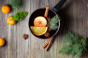 tasty mulled wine hot drink with mandarin orange apple spices and christmas tree in pot