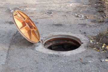 an open manhole cover on the road.violation of safety regulations