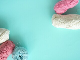Skeins of yarn for knitting in white, pink and blue. Place for your text. Corner filling.