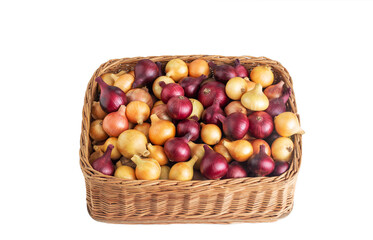 Multicolored yellow and red onions in a wicker basket on a white background, isolate, vegetable