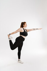 Smiling young plus size fitness woman in sportswear