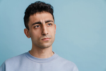 Fototapeta premium Young middle eastern man frowning and looking aside