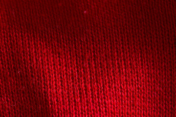 Fototapeta premium Red knitted sweater close-up. Material background, macro