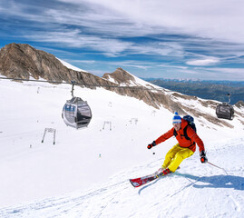 Skier skiing downhill during sunny day in high mountains, Kaprun glacier- Zell am see, Austria