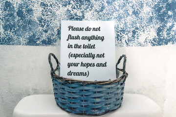 Toilet sign in basket with text 'Please do not flush anything in the toilet - especially not your...
