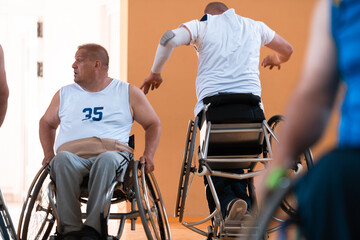 Close up photo of wheelchairs and handicapped war veterans playing basketball on the court