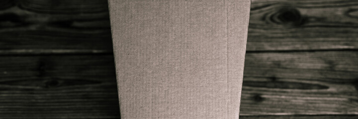 mockup empty craft trapezoidal cardboard box on an old wooden table close up. tinted in black color. top view, flat lay and space for text. banner