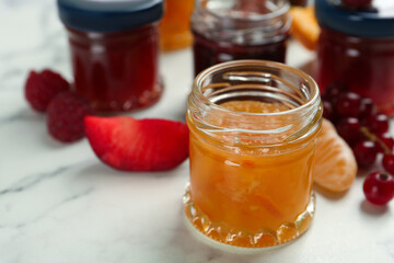 Jar of sweet jam on white marble table, closeup. Space for text