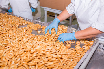 Bakery Bread Industry, Man working with hands working collects in boxes packaging candy factory, cookies and bagels or donuts a lot to make at a baking factory dessert, with a copy space