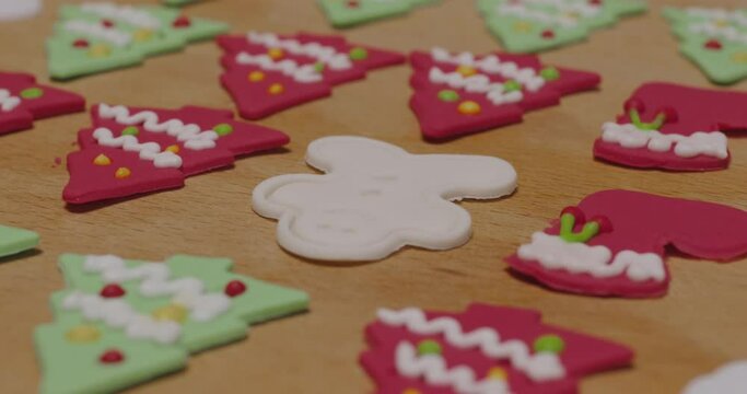 Close-up hand enjoy fun make craft gift party snack tasty cooking recipe on table in good warm relax time. Cute smile gingerman mold shape bakery royal icing sugar glaze with red green white color.