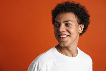 Young black man in t-shirt laughing while looking aside