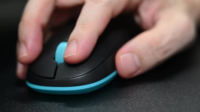 A man is playing games using a bluetooth Logitech mouse.