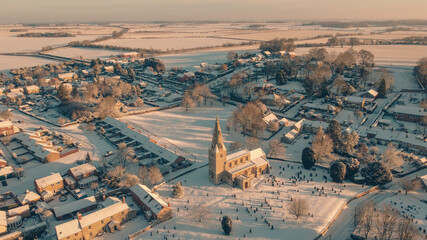 snowy village with church from drone