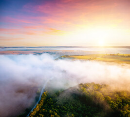 Obraz premium Awesome misty view of farmland and cultivated fields with a country road.