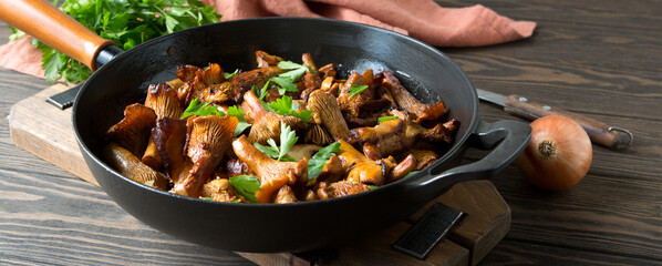 frying pan with fried chanterelles on the table - obrazy, fototapety, plakaty